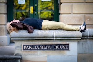 Martine Delaney lying on the steps of Parliament House, Hobart.